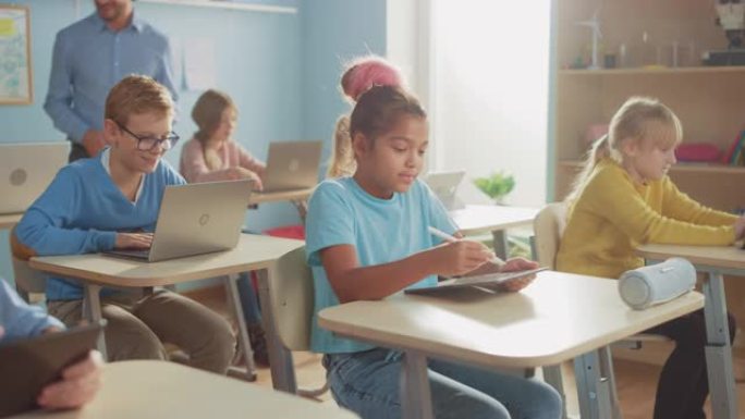 学校计算机科学课: 女孩使用数字平板电脑，她的同学使用笔记本电脑，老师在课堂上散步帮助孩子。儿童在S