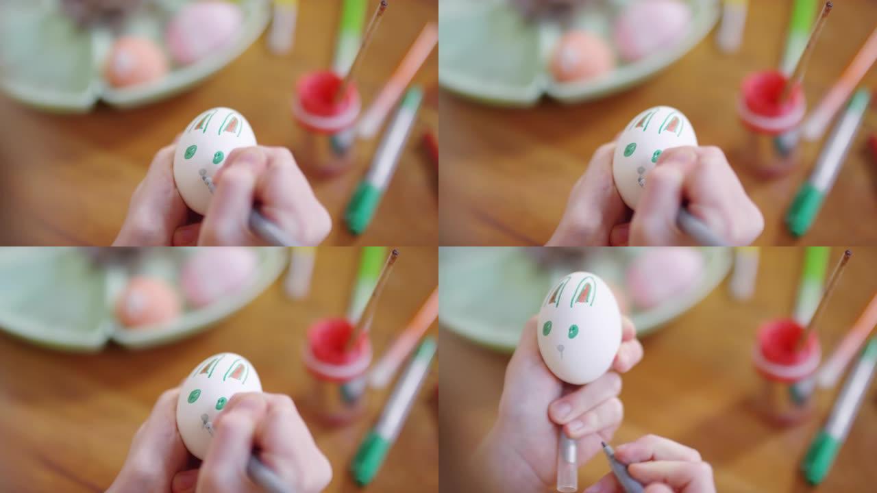 儿童在复活节彩蛋上绘画的手