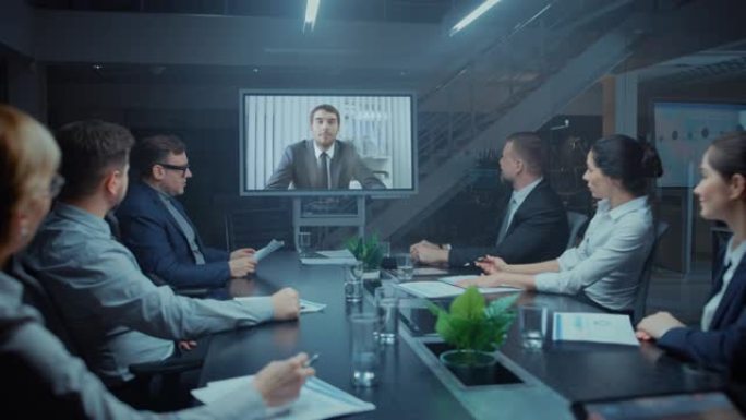 在会议室中，由董事，投资者和商人组成的小组进行深夜视频电话会议，与国际公司代表交谈