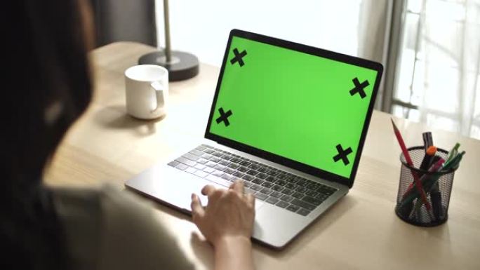 亚洲女性在家中使用笔记本电脑绿屏