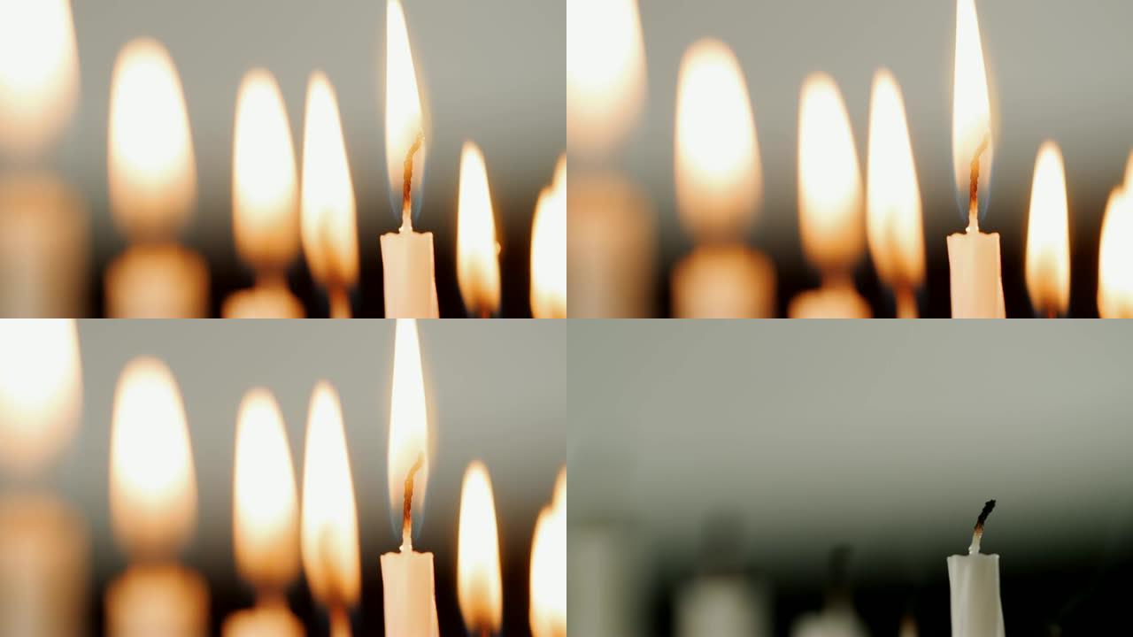详细拍摄了一组白色蜡烛上的火焰，为犹太节日光明节燃烧，这些蜡烛被吹灭，选择性聚焦