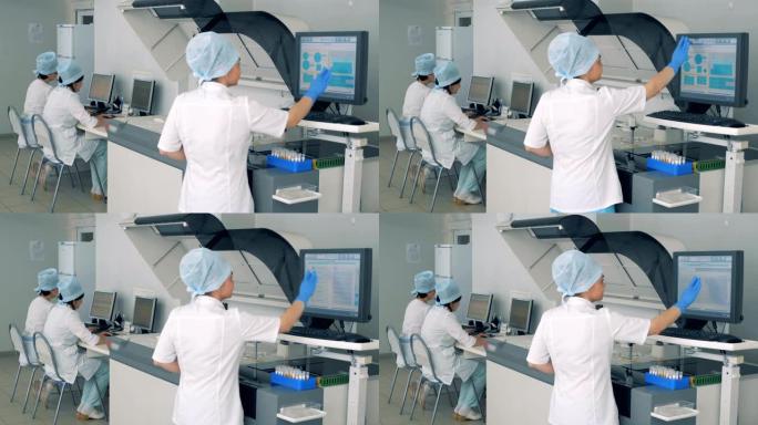 女实验室专家正在一家制药厂的触摸屏上操纵生化分析仪。