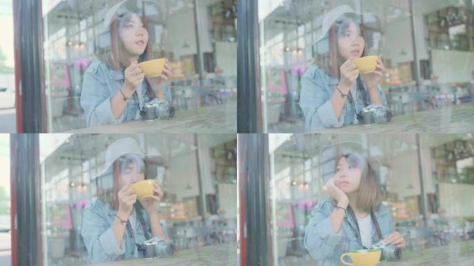 商业自由亚洲女性坐在咖啡馆的桌子上喝一杯温暖的绿茶或咖啡。生活方式聪明美丽的女性在咖啡店概念中放松。