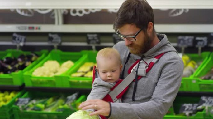 父亲带着婴儿在超市买白菜