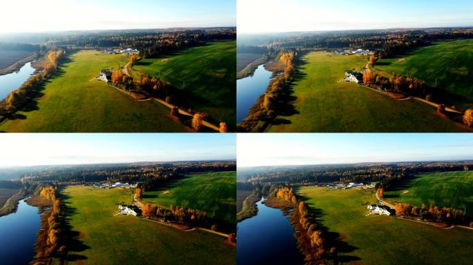 在阳光明媚的日子里，无人驾驶飞机飞越美丽的秋天日出场、湖泊和森林，露出大农场和豪宅。