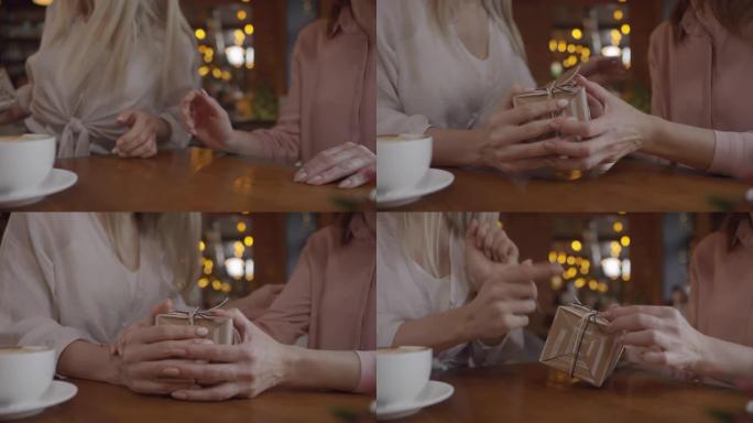 无法辨认的女人在咖啡馆里给母亲礼物