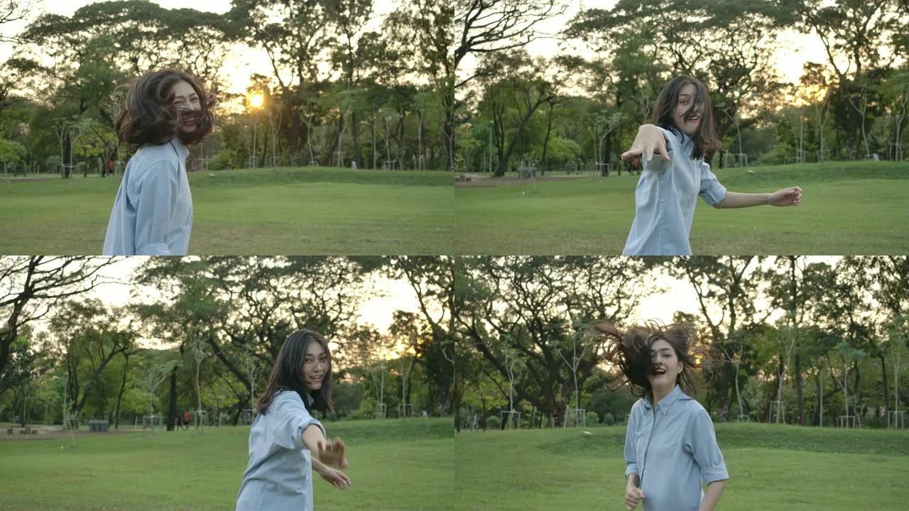 日落时在夏季公园跑步的年轻迷人亚洲女子的慢动作镜头。美丽的女孩在户外享受大自然。