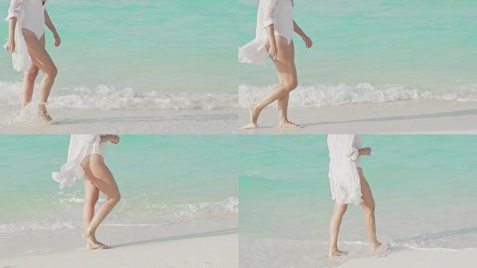 女士女士在马尔代夫白色沙滩上阳光明媚的蓝色海洋冲浪中涉水