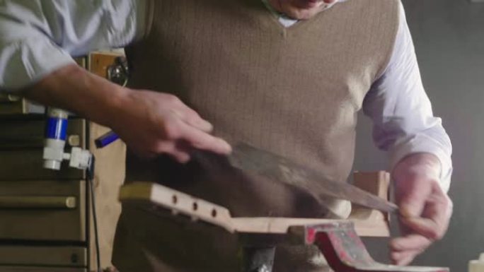 在他的实验室里，一位liutist为音乐家制作高质量的吉他，用优质的木材加工。