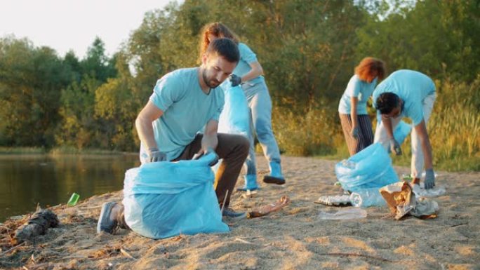 努力工作的年轻人从事义务工作，从垃圾中清理海滩