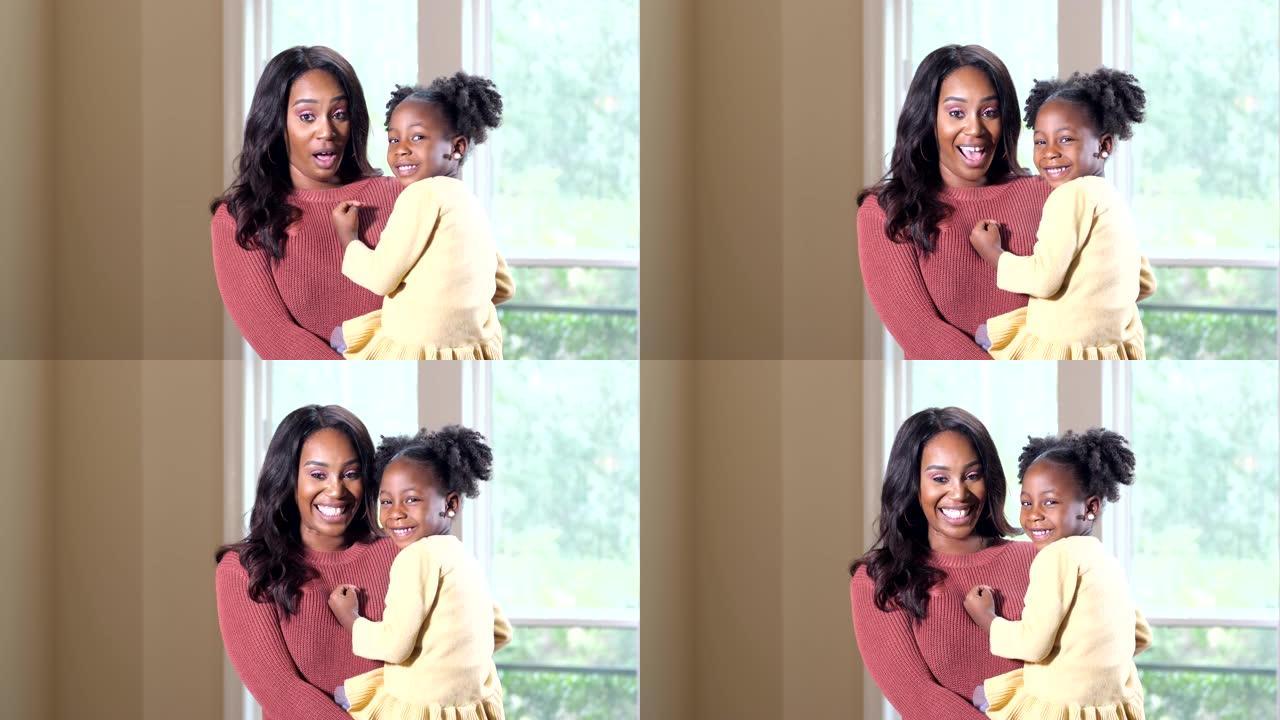 年轻的非洲裔美国母亲抱着小女孩