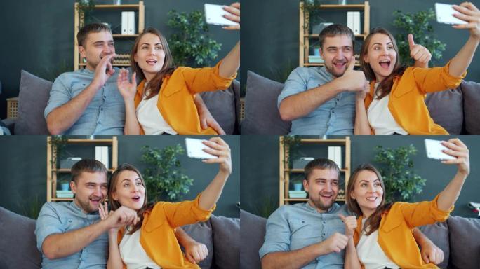 幸福的年轻夫妇在家中用智能手机自拍，摆姿势