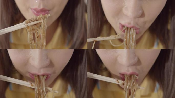 亚洲妇女吃面条的特写镜头