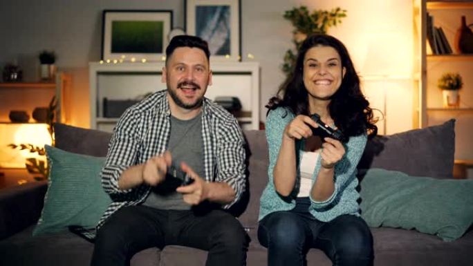 男人和女人在公寓里玩电子游戏，快乐女孩获胜