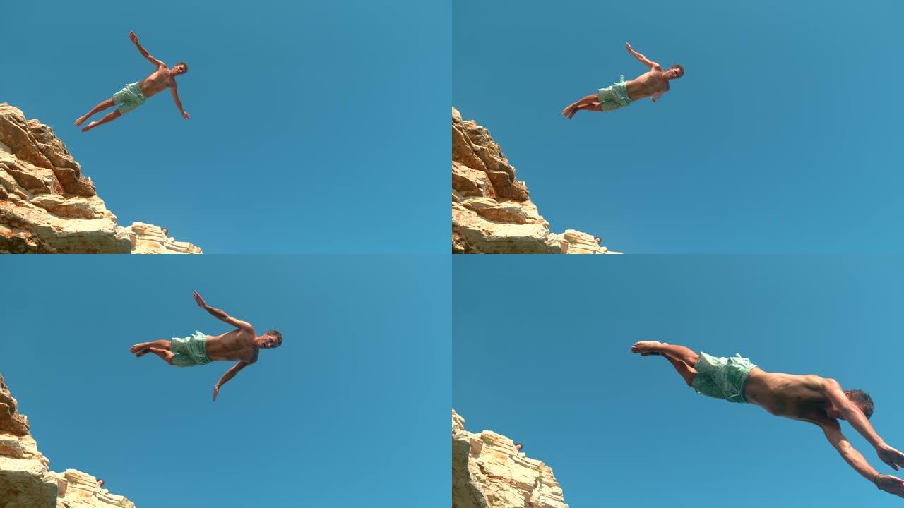自下而上: 运动游客跳下悬崖，潜入清新的海洋。