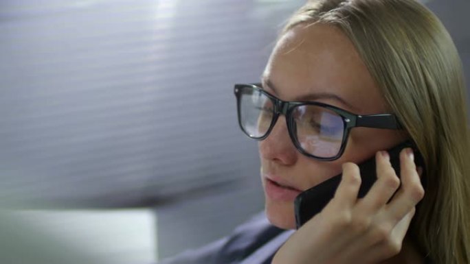 戴着眼镜的女商人的脸在电话上聊天