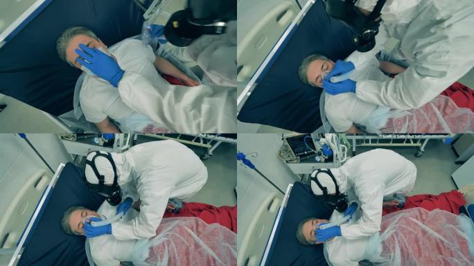 医务人员正在将一个人连接到呼吸系统。冠状病毒，新型冠状病毒肺炎医院重症监护室的病人。