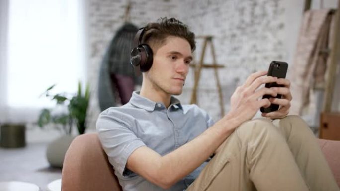 千禧一代男性在手机上发短信并听音乐