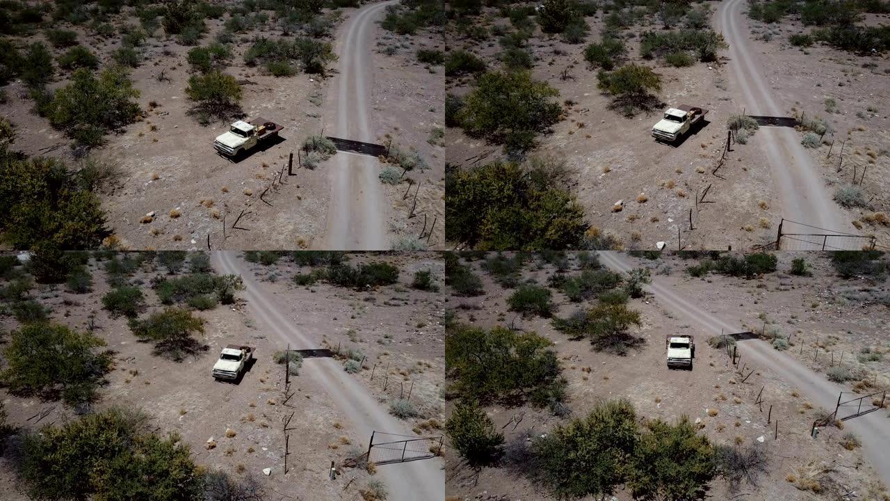 无人机在砂岩砾石沙漠路附近的孤独废弃老式皮卡上方飞行，在美国夏季炎热中迷失。