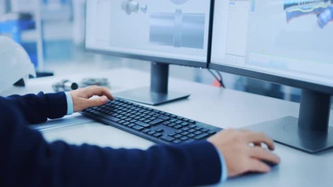 工业工程师解决问题，使用鼠标和键盘在个人计算机上工作，两个监视器屏幕显示3D的cad软件和机器设备。