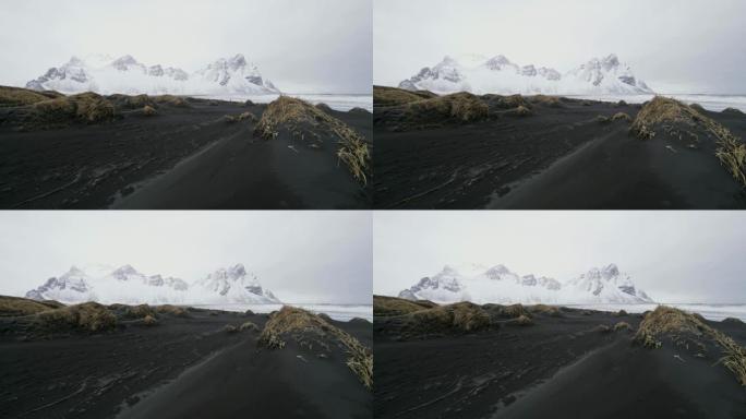 冰岛斯托克尼斯海滩黑沙海滩外的白雪山风景