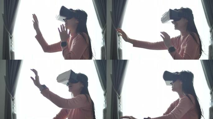 年轻的亚洲妇女在她的公寓里使用VR耳机放松，女人使用虚拟现实。美丽的年轻女性在vr眼镜上玩游戏。