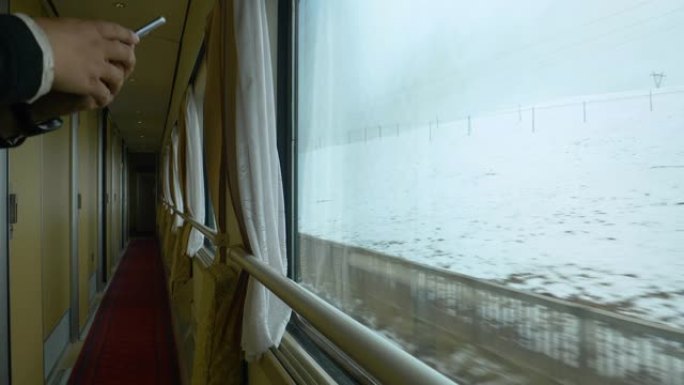 特写: 无法辨认的游客在乘坐火车时拍摄雪藏的照片。