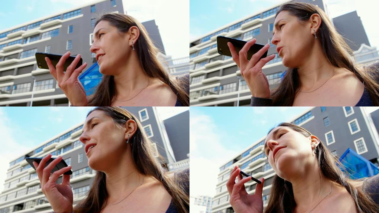 城市4k中女人在手机上说话的低角度视图