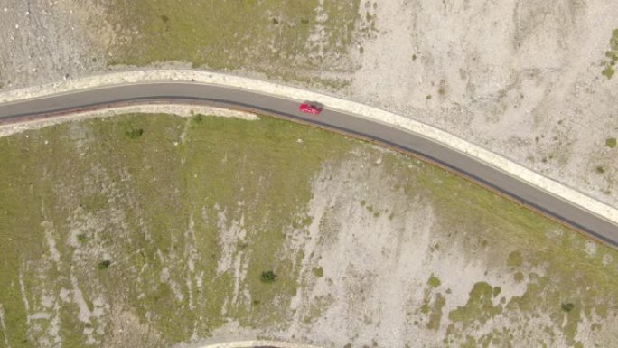 空中: 红色跑车探索美丽的意大利阿尔卑斯山的弯曲道路。