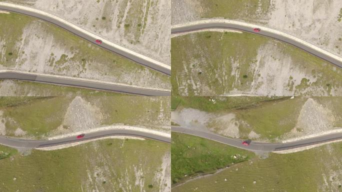 空中: 红色跑车探索美丽的意大利阿尔卑斯山的弯曲道路。