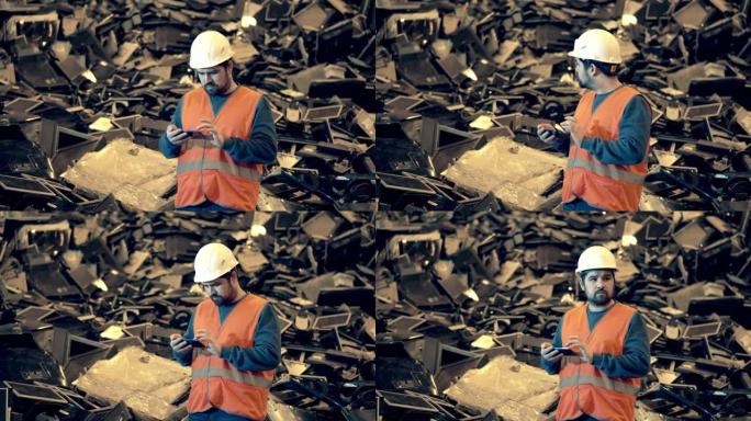 电子垃圾回收厂。垃圾填埋场的男性工人被丢弃的计算机