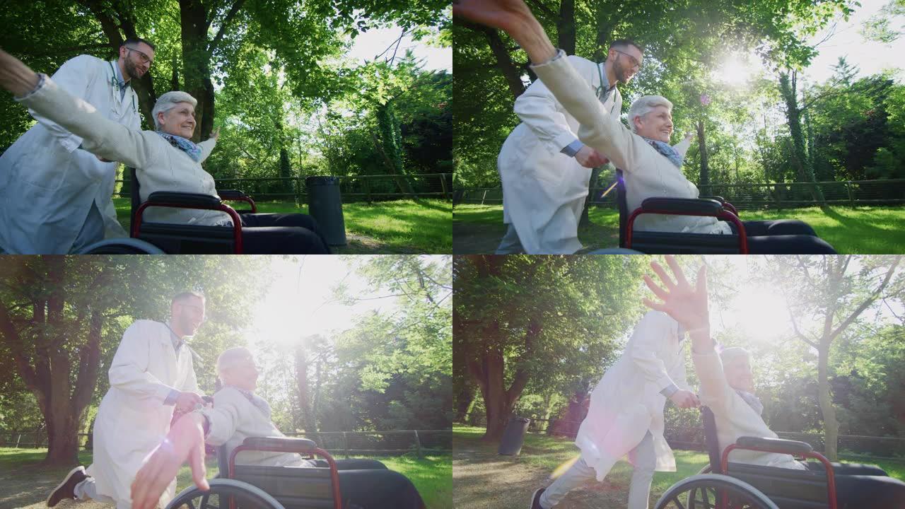 无忧无虑快乐的社会工作者和坐在轮椅上的老年妇女的慢动作，在阳光明媚的日子里在绿色公园里玩耍