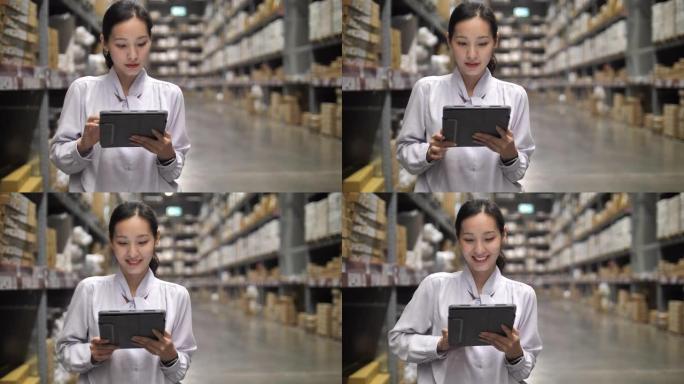 亚洲女商人在仓库中使用数字平板电脑，在仓库中使用技术