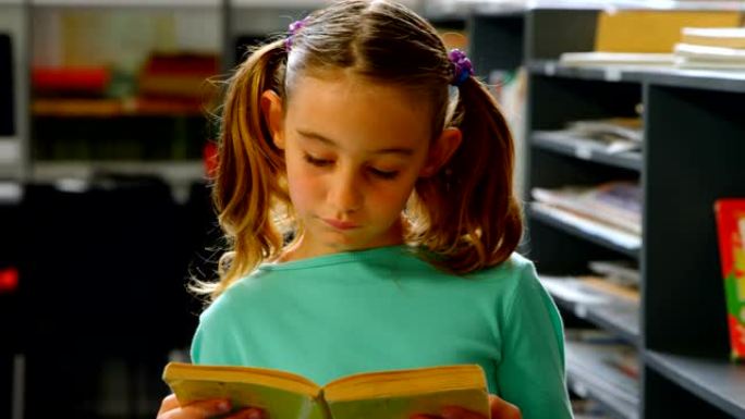 细心的高加索女学生在4k学校图书馆看书的前视图