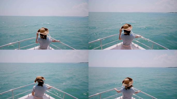 美丽的高角度后视图拍摄快乐成功的旅游女人在游艇船鼻子上享受着惊人的阳光海上航行。