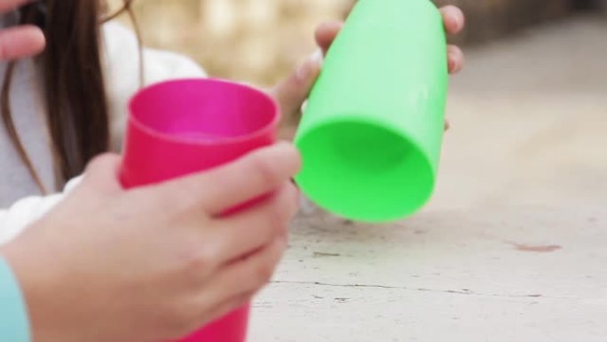 玩塑料杯的年轻女孩。