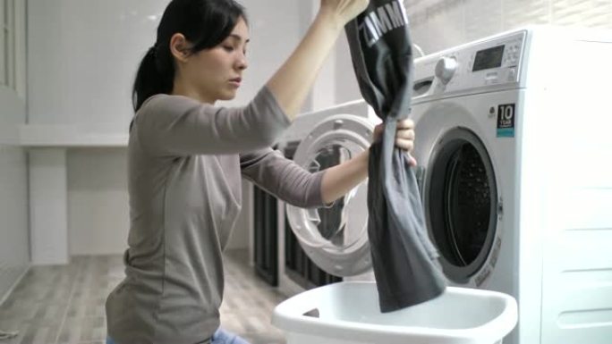女人在家用洗衣机洗衣服