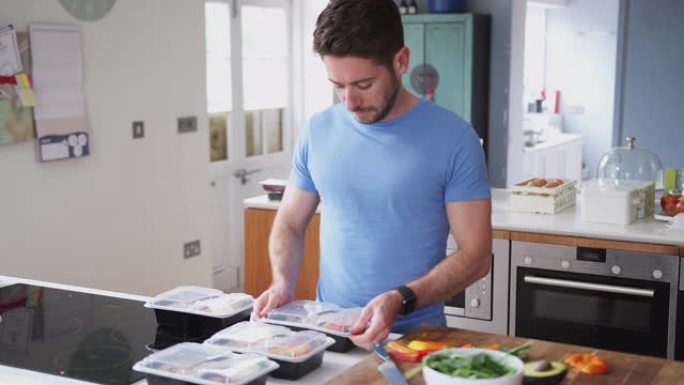 穿着健身服的男子在家中厨房准备健康餐