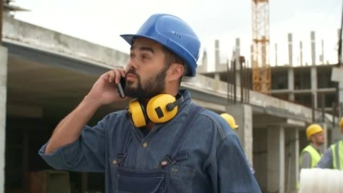 建筑工地工头边走边聊电话