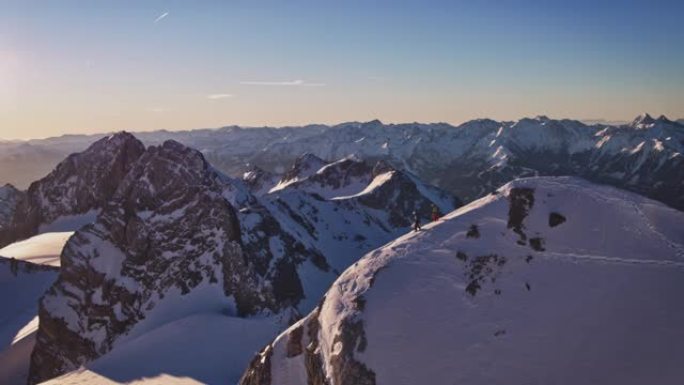 在积雪覆盖的山脊上行走的成熟男性徒步旅行者