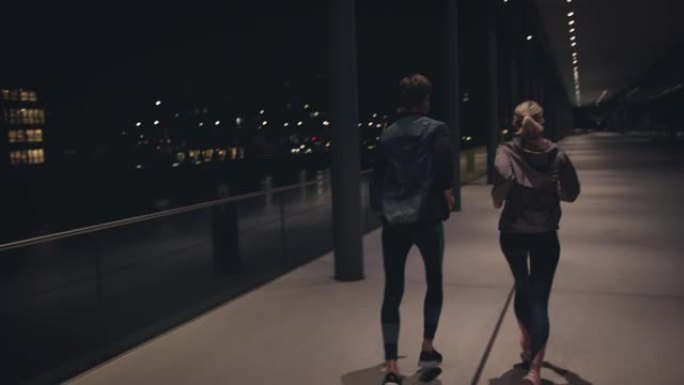 年轻夫妇在城市的高架人行道上奔跑
