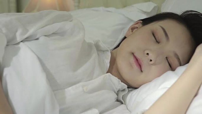 年轻的亚洲妇女睡在床上
