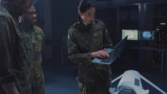 陆军航空航天工程师研究无人机。使用笔记本电脑的制服航空专家谈话。用于执行监视、作战战术、目标打击的飞