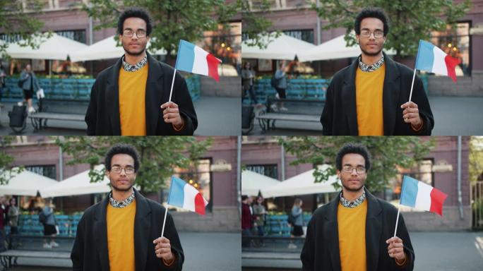 一个非裔美国人站在外面举着法国国旗的慢动作肖像