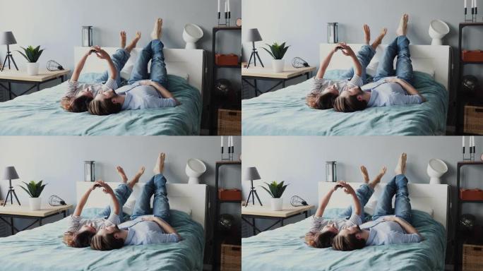 无忧无虑的年轻夫妇使用现代智能手机躺在床上放松