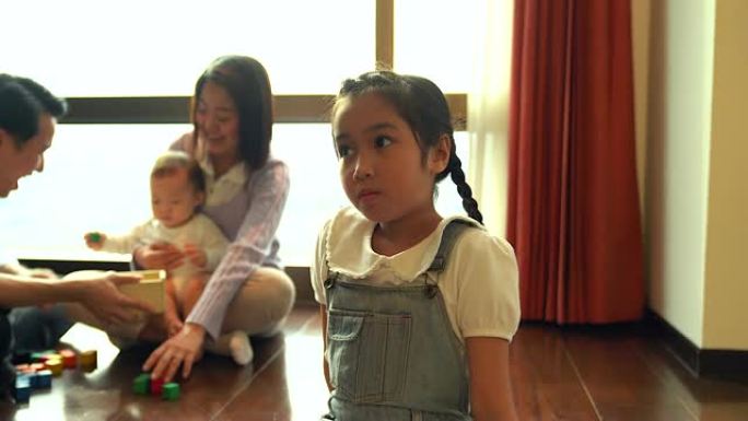 不幸嫉妒的小女孩，她的家人在后台。