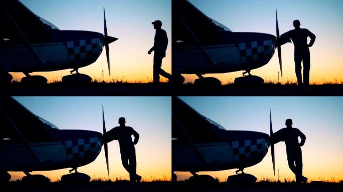 飞机驾驶员站在日落背景上，特写。