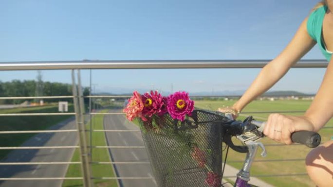 特写: 骑自行车的年轻女子收到美丽的花朵后微笑。