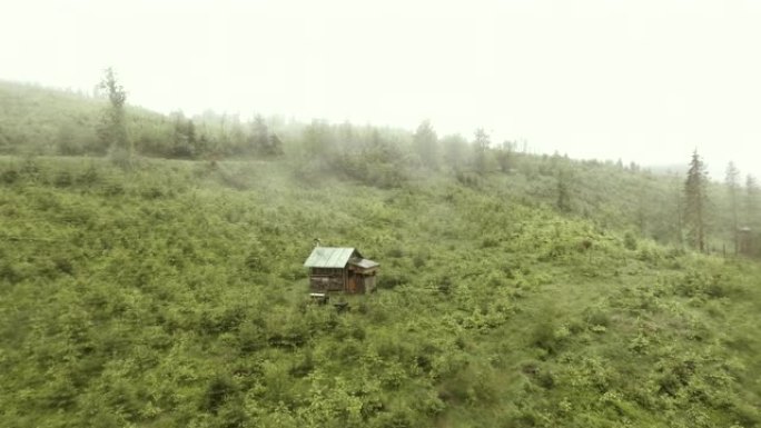 探索荒野。雾天有小屋的山地景观