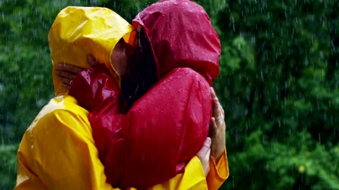 一对情侣，恋爱中的男人和女人在大自然的雨中跳舞，亲吻和玩耍快乐的微笑。自由和爱。